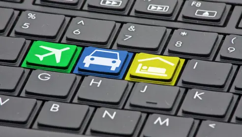 Et tastatur med fly, bil og hotel-ikoner