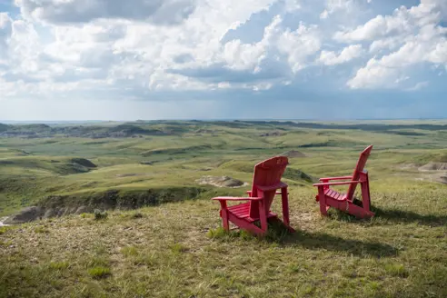 Røde stole med udsigt over Grasslands National Park i Saskatchewan, Canada