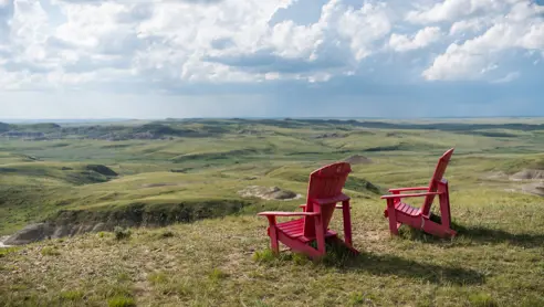 Røde stole med udsigt over Grasslands National Park i Saskatchewan, Canada