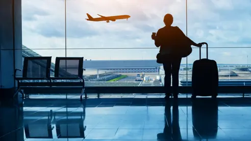 Kvinde i lufthavn kigger på fly