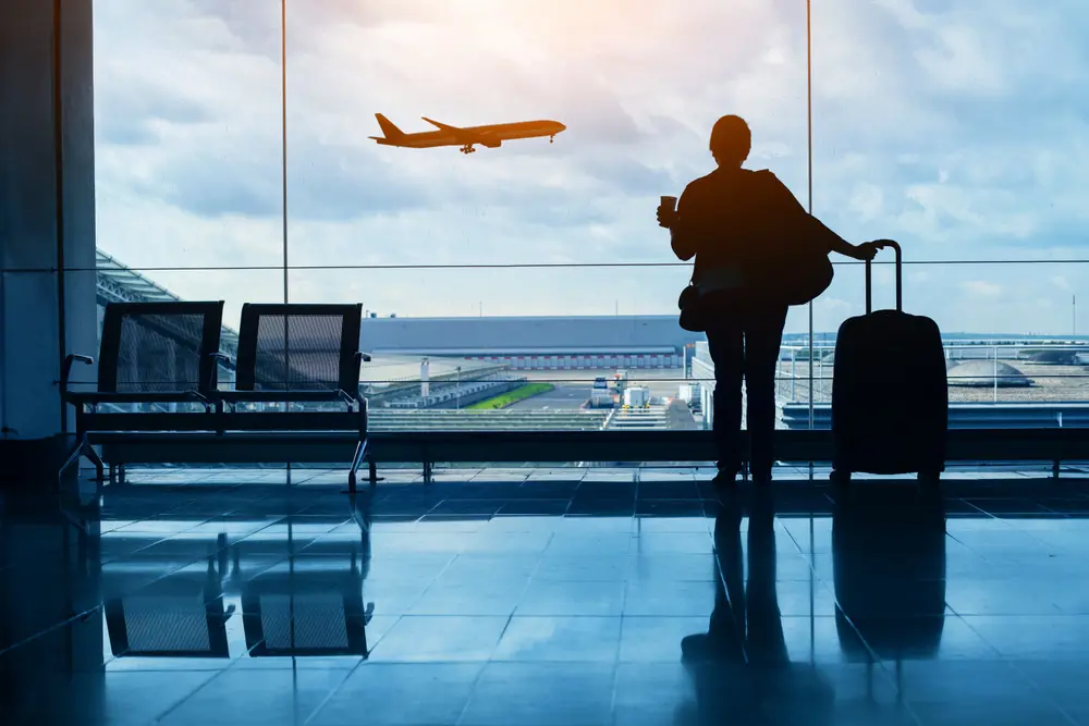Kvinde i lufthavn kigger på fly